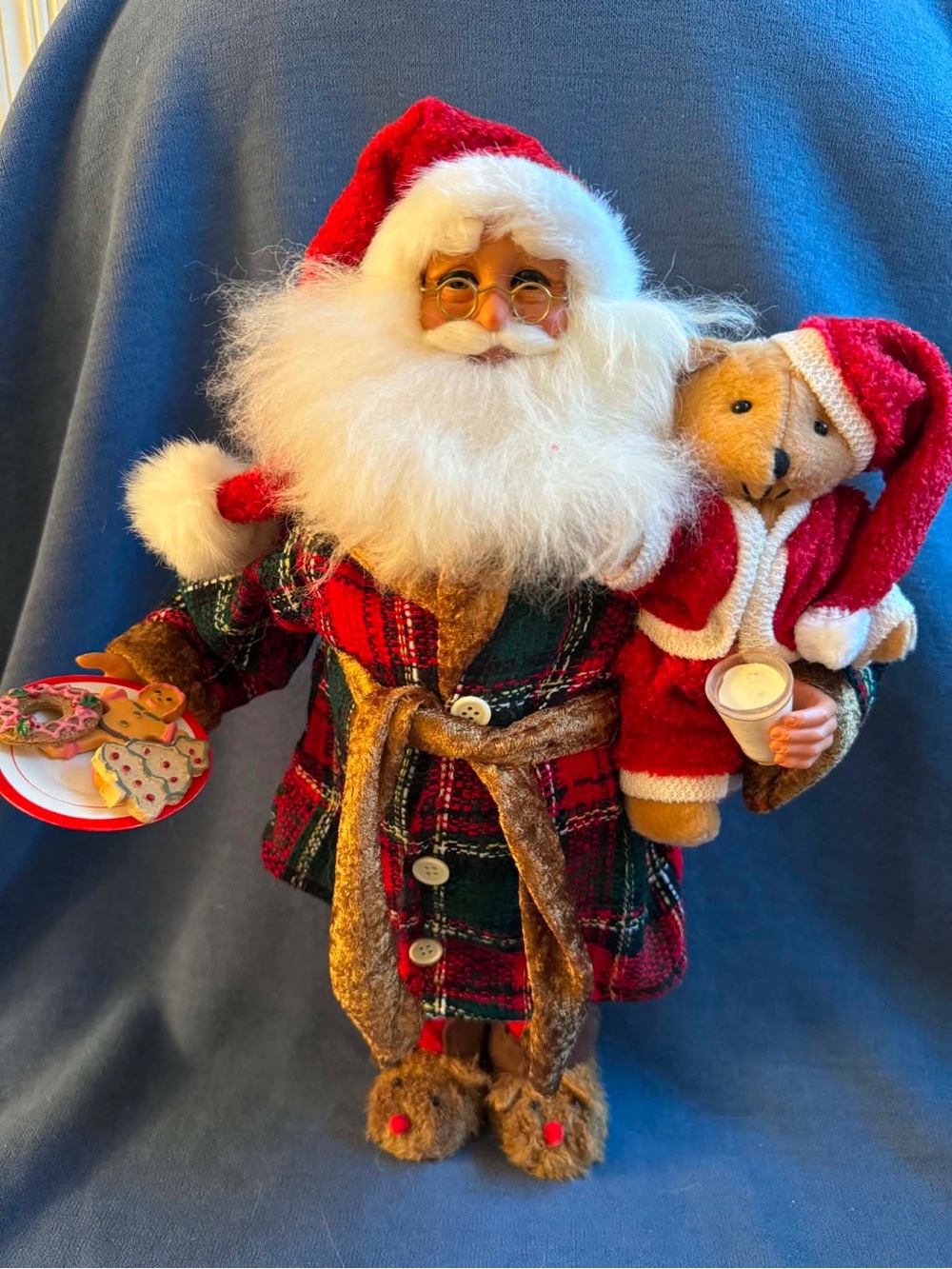Karen Didion Santa in plaid pajamas with cookies and a teddy bear .